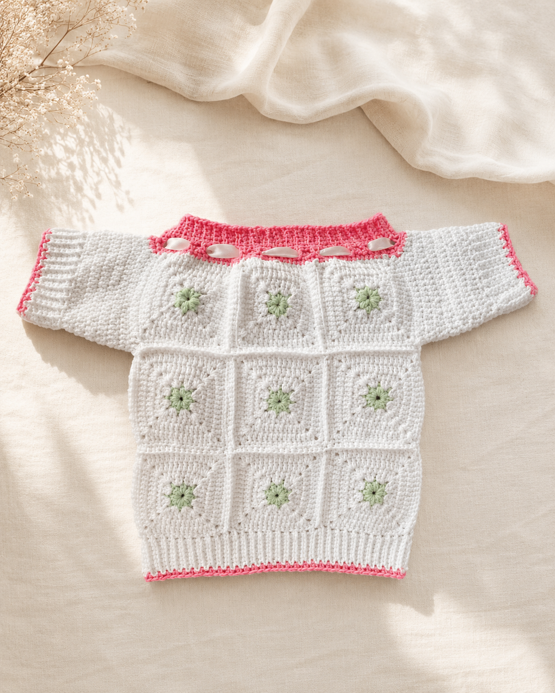Vit babytröja med gröna blomdetaljer